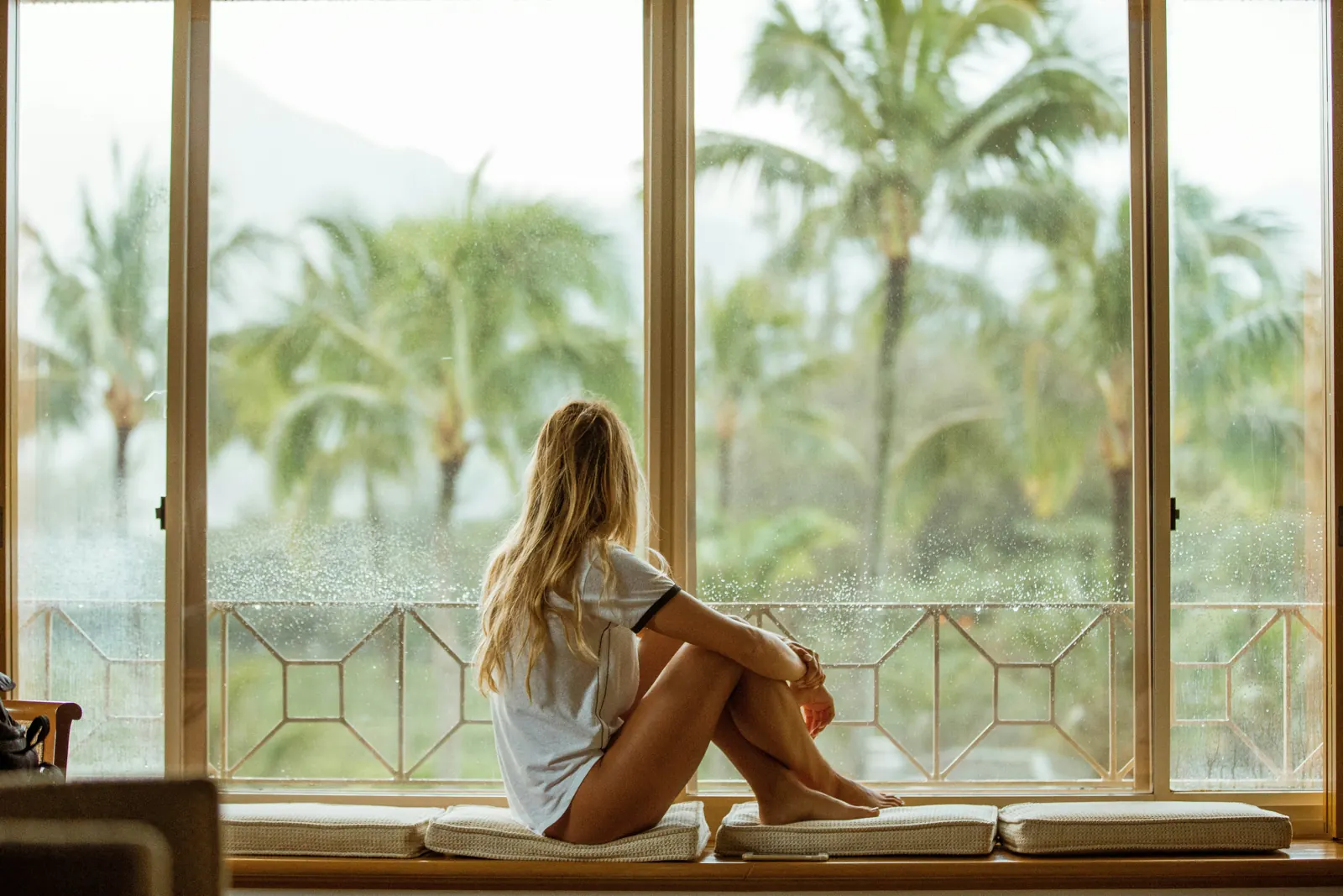 A woman sitting quietly by a window, thinking about what comes next